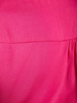Top fuchsia en dentelle à coupe péplum col cache-coeur et à manches longues