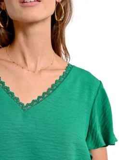 Top vert uni avec une coupe droite un col v et des manches courtes