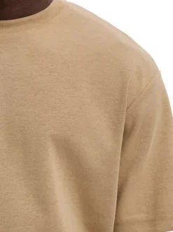 T-shirt beige uni coupe ample avec un col rond et des manches courtes