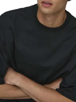 T-shirt en coton noir uni épais avec une coupe très oversize et un col rond