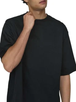 T-shirt en coton noir uni épais avec une coupe très oversize et un col rond