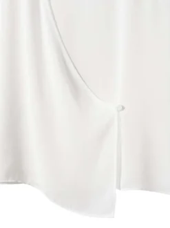 T-shirt sans manches blanc uni avec une coupe asymétrique et un col rond