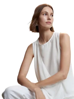 T-shirt sans manches blanc uni avec une coupe asymétrique et un col rond