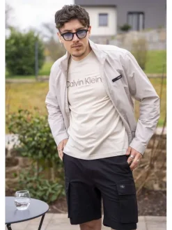 Veste blanche légère avec un aspect satiné un col montant et des poches