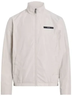 Veste blanche légère avec un aspect satiné un col montant et des poches